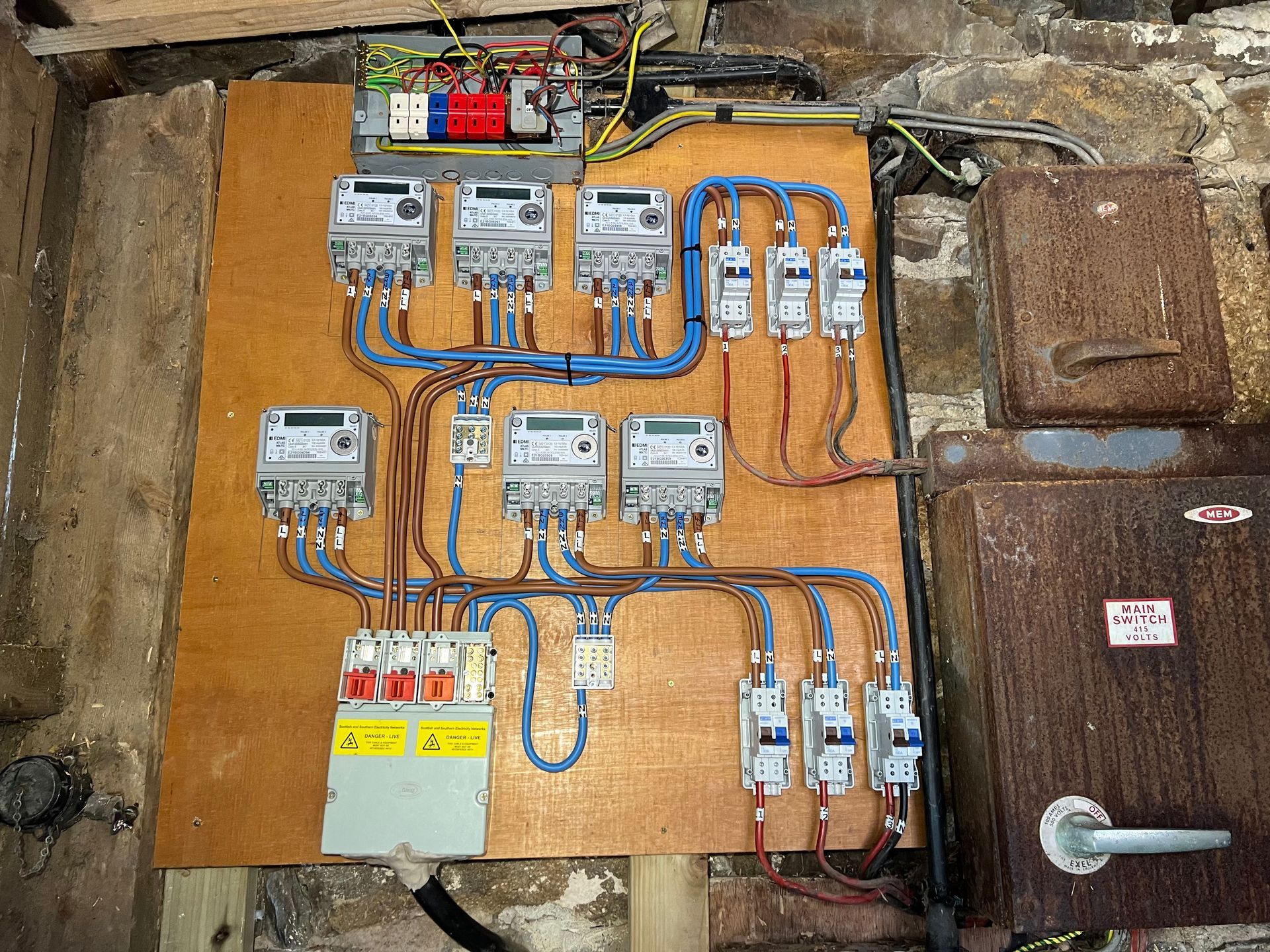 A wooden board with a bunch of electrical equipment on it