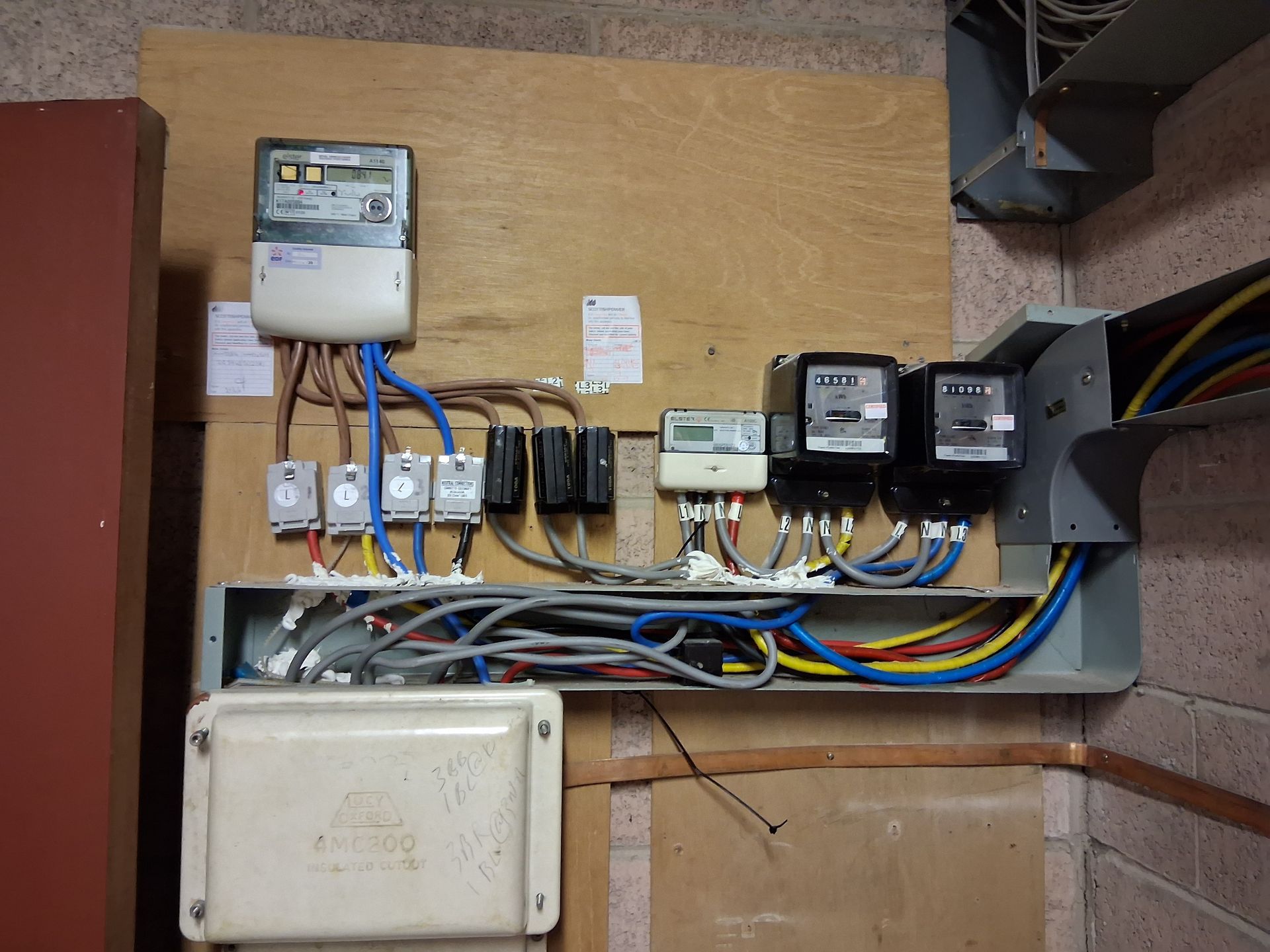 A wall with a bunch of wires and a few meters on it