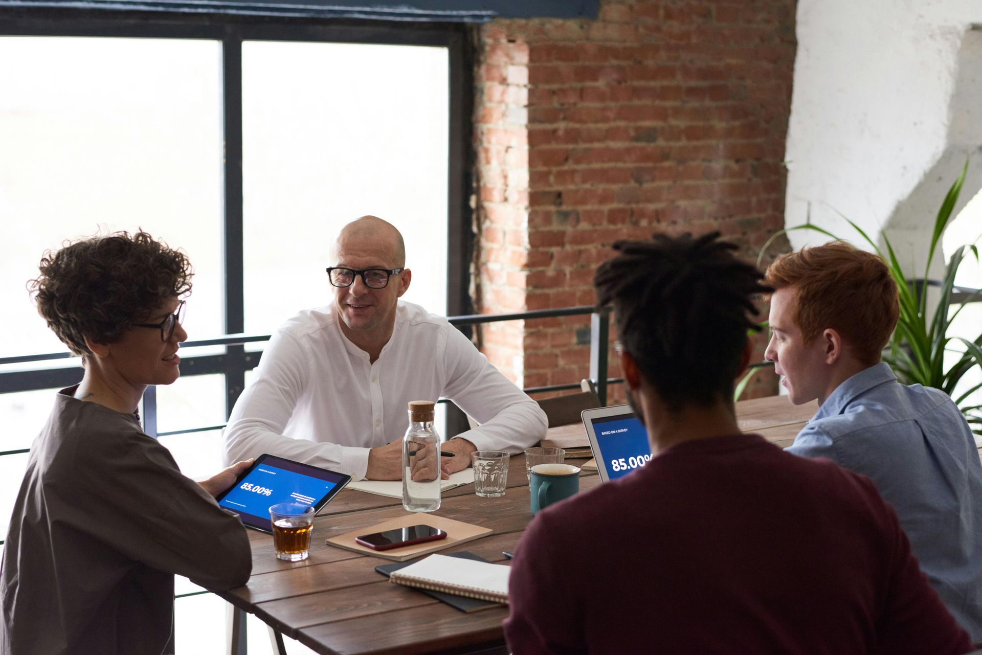 A group of people are sitting around a table having a meeting.