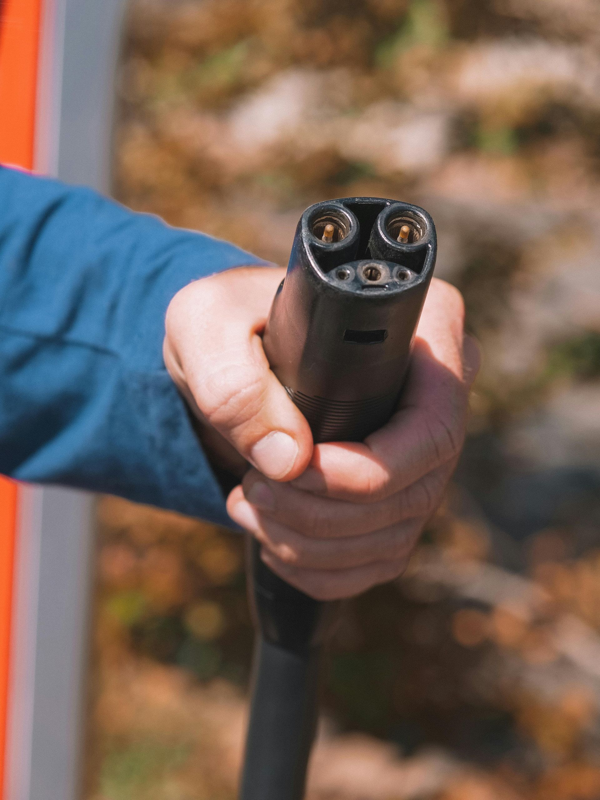 A person is holding a charging cable in their hand.