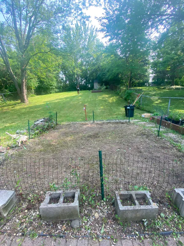A fenced in yard with concrete blocks in the middle of it.