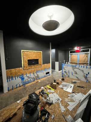 A room under construction with a vacuum cleaner on the floor.