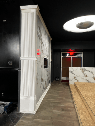 A room with a marble wall and a wooden floor.