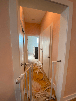 A hallway with a baby gate in the middle of it.