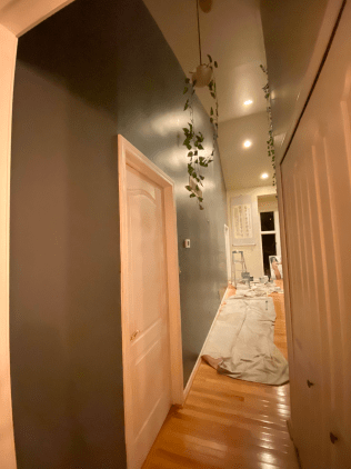A hallway is being painted in a house.