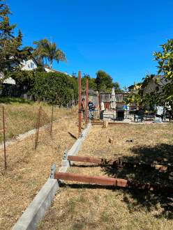 A fence is being built in the backyard of a house.