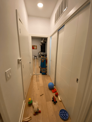 A hallway with a lot of toys on the floor.
