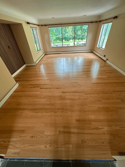 A living room with hardwood floors and lots of windows.