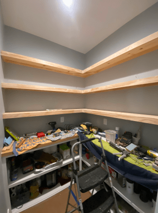 A room with shelves and a ladder in it
