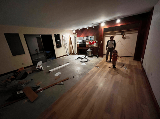 A man and a child are standing in a room that is being remodeled