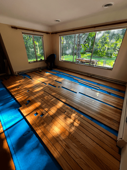 A room with a wooden floor and a lot of windows.