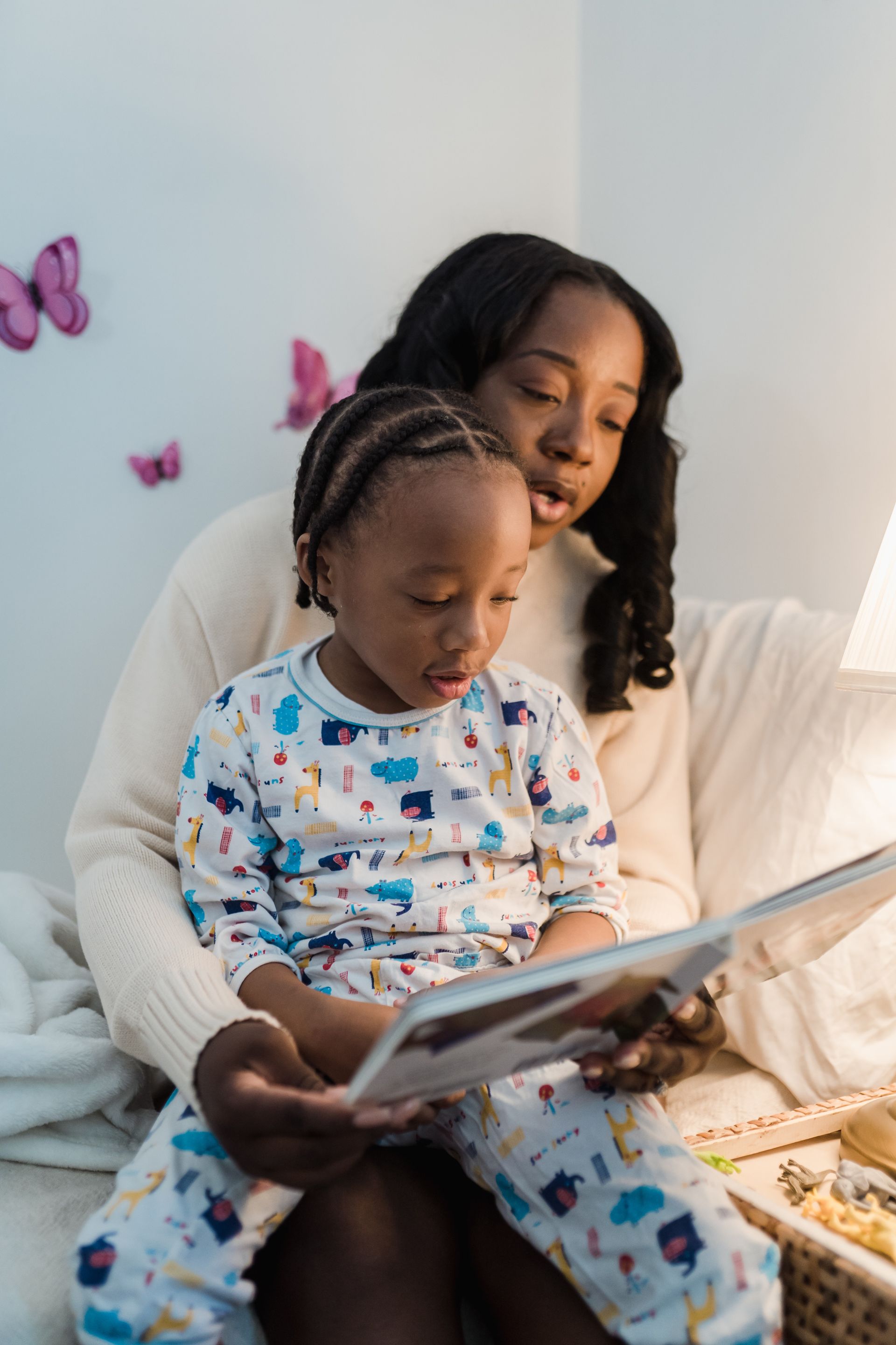 Mother reading a book to her child before bed