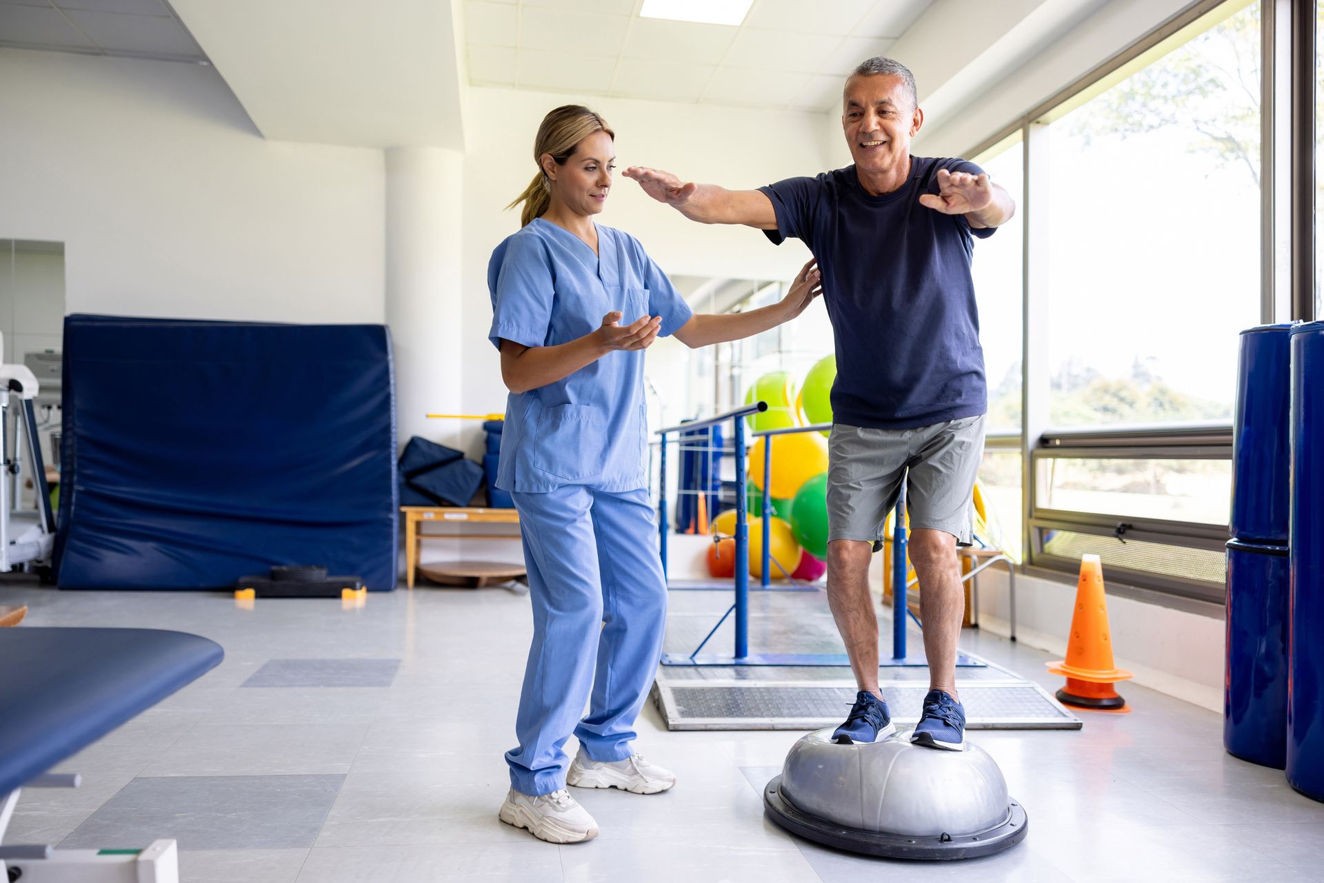 Man doing physical therapy exercises using a balance ball. Man doing physical therapy exercises using a balance ball.