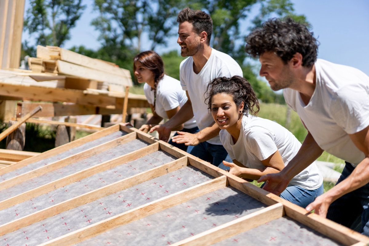 A group of people are working on a wooden structure