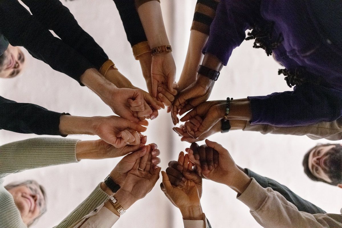 A group of people are holding hands in a circle