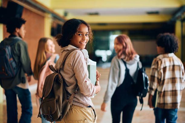 A group of young people are walking down a hallway