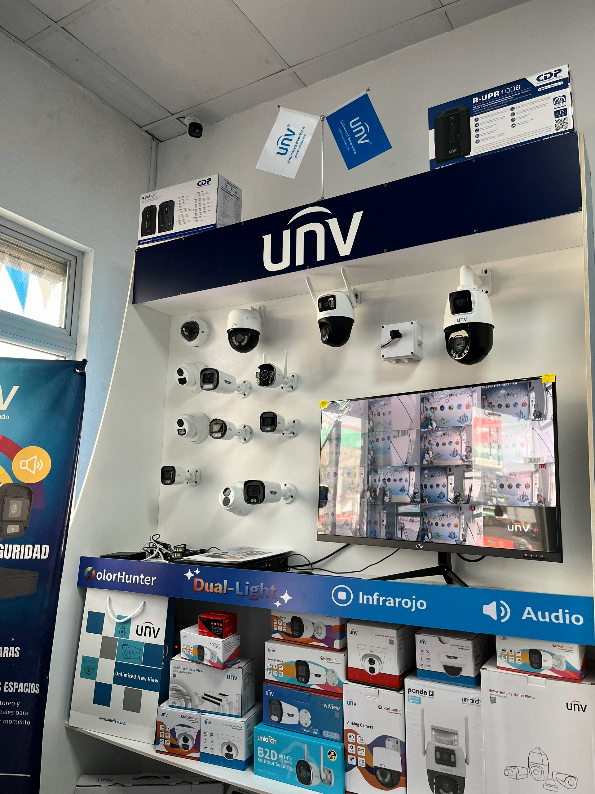 Exhibición de cámaras y equipos de seguridad del VNU en una tienda, incluido un monitor y cajas.