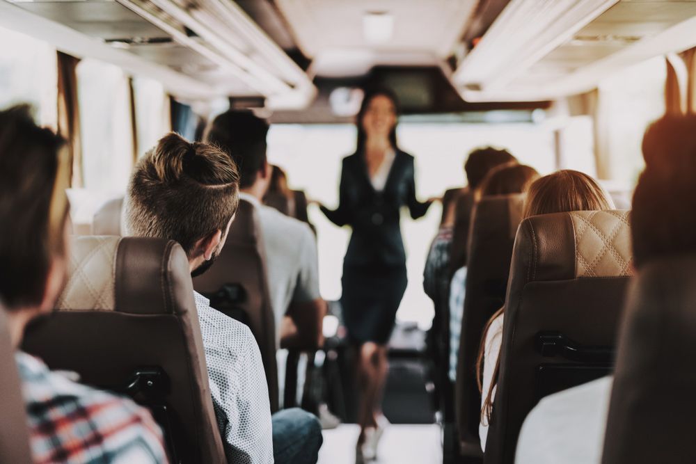 A Woman Is Giving a Presentation to A Group of People on A Bus — G & D Ross Bus Charters In Gladstone, QLD