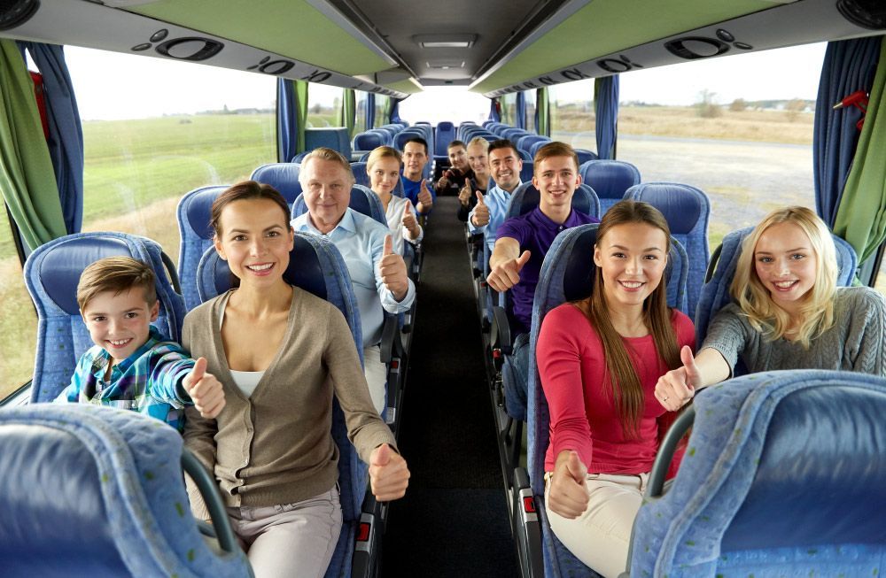A Group of People Are Sitting on A Bus Giving a Thumbs Up — G & D Ross Bus Charters In Gladstone, QLD