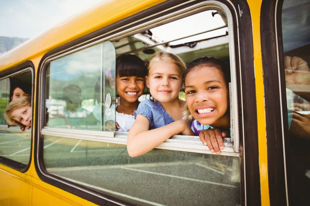 A Group of Children Are Looking out Of a School Bus Window — G & D Ross Bus Charters In Childers, QLD