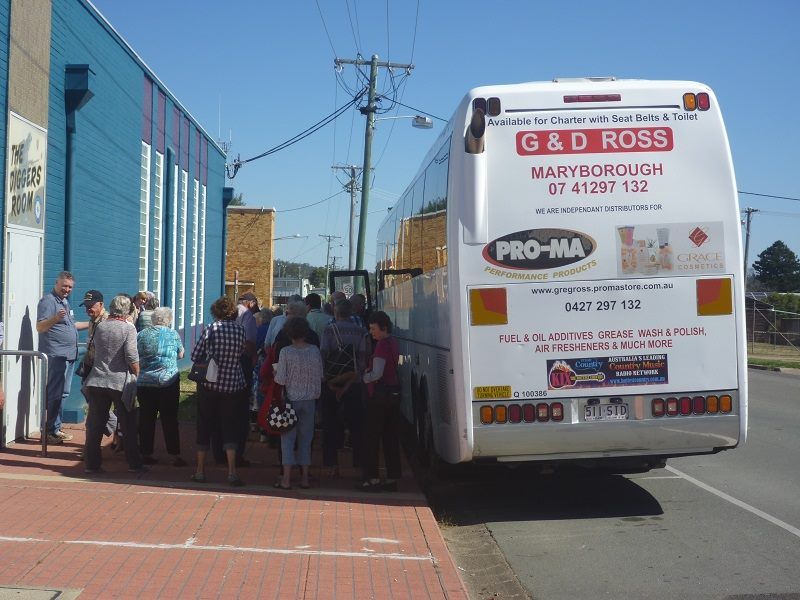 A Group of People Standing in Front of A Bus that Says G & D Ross — G & D Ross Bus Charters In Maryborough, QLD