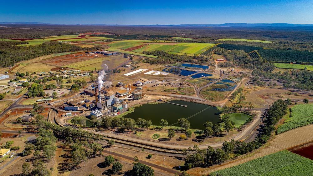 An Aerial View of A Sugar Refinery Surrounded by Fields and Trees — G & D Ross Bus Charters In Childers, QLD