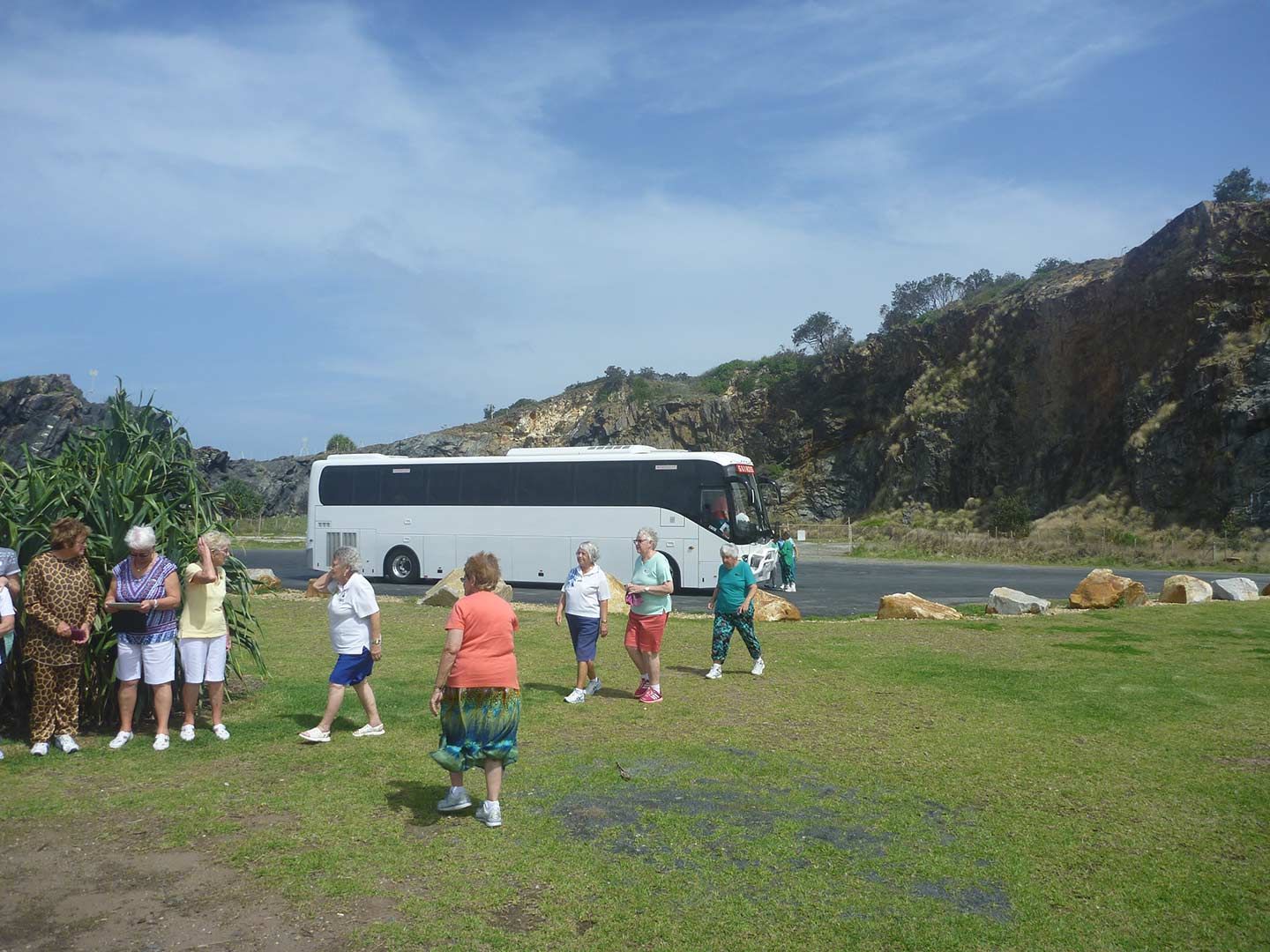 A Group of People Standing in Front of A White Bus — G & D Ross Bus Charters In Emerald, QLD