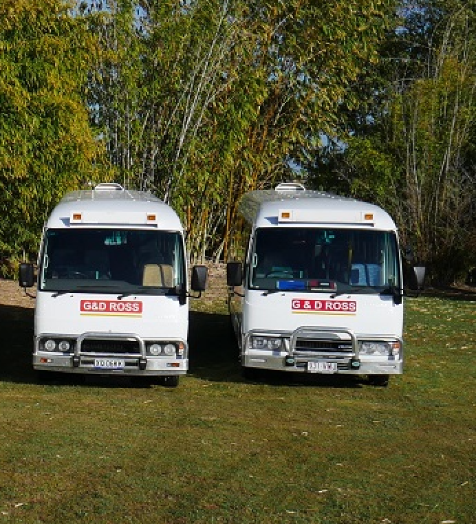 2 Mini Buses Parked in A Field — G & D Ross Bus Charters In Magnolia, QLD