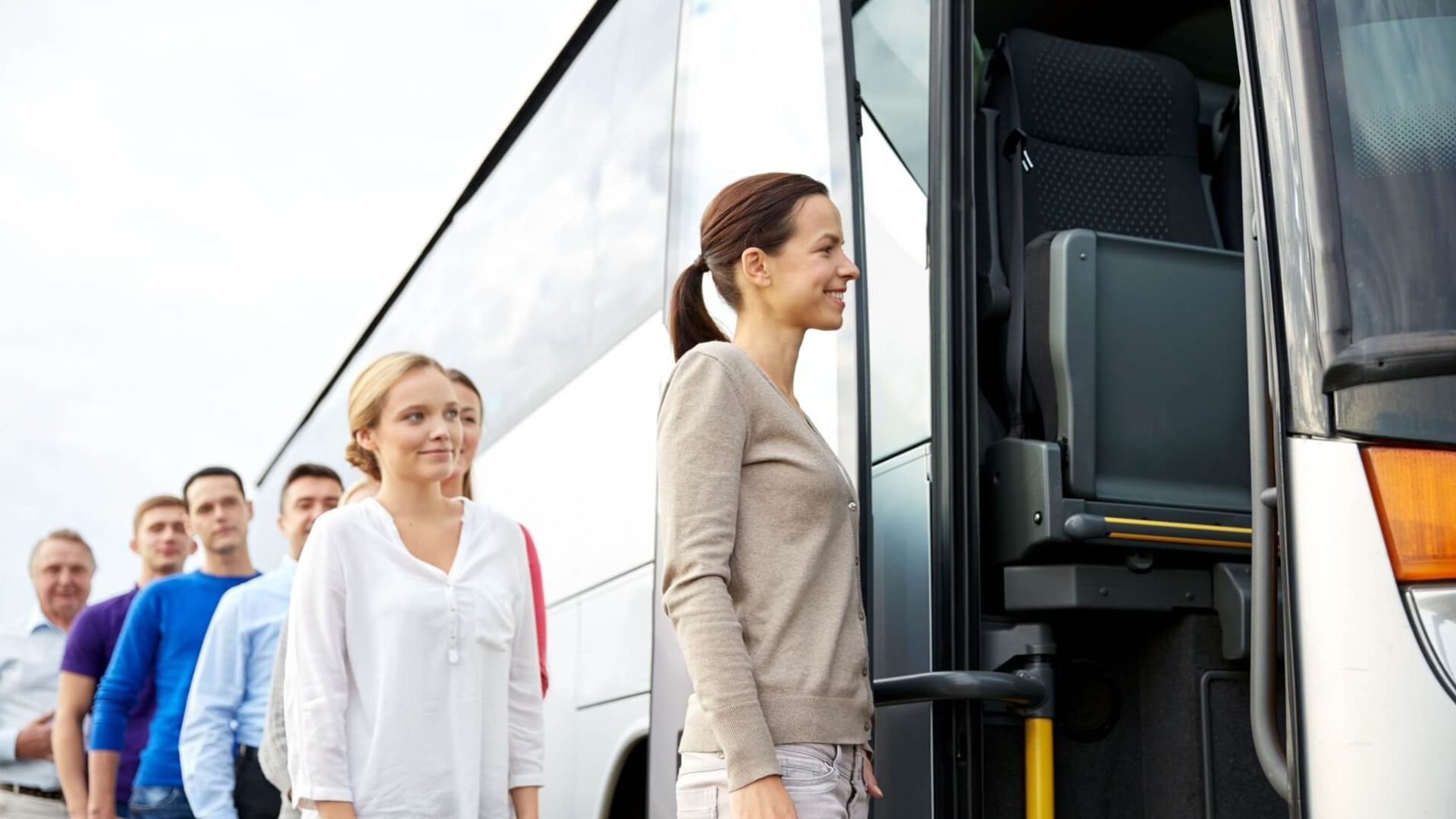 A Group of People Are Standing in Line to Board a Bus — G & D Ross Bus Charters In Magnolia, QLD