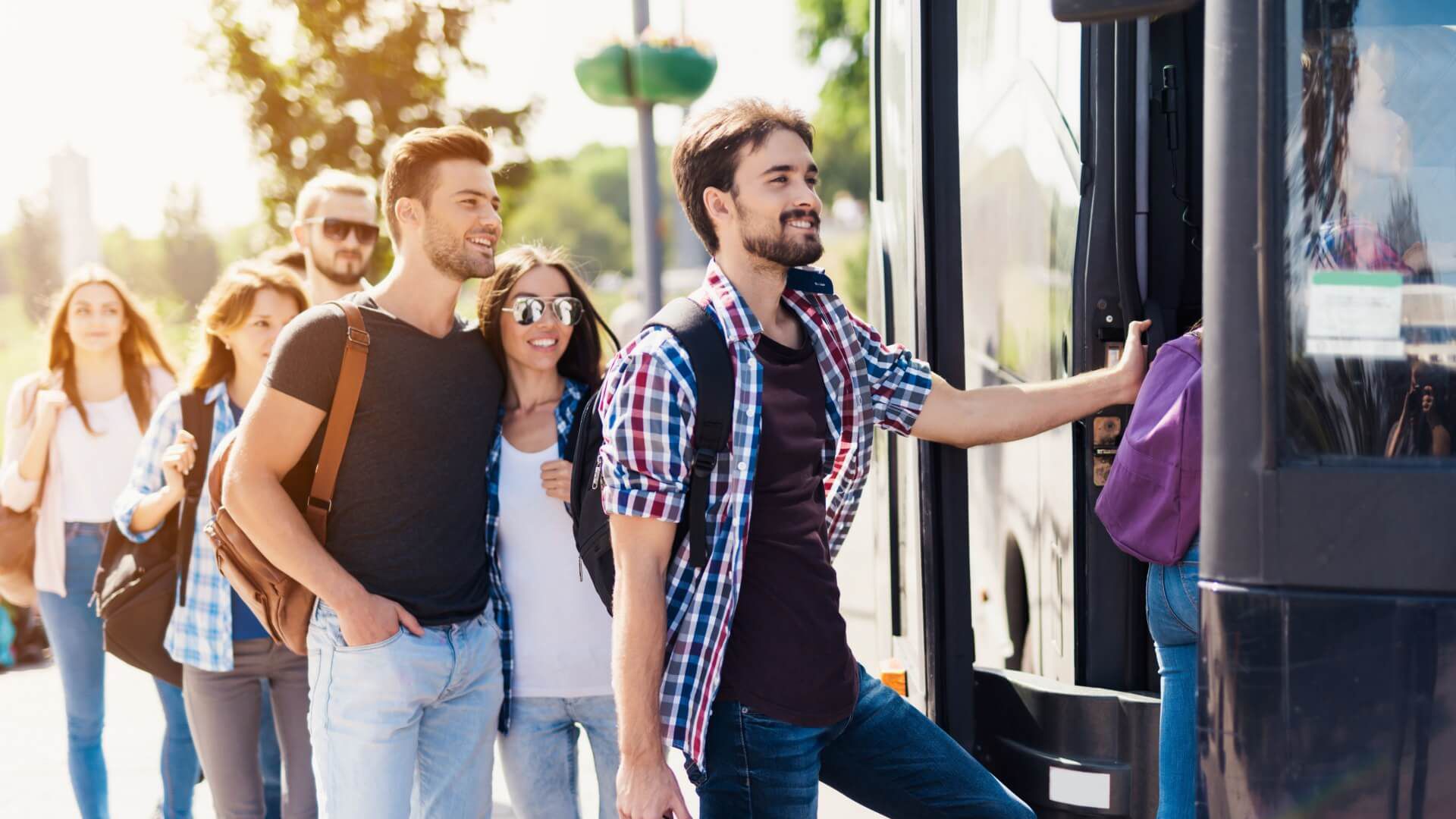 A Group of People Are Boarding a Bus at A Bus Stop — G & D Ross Bus Charters In Magnolia, QLD