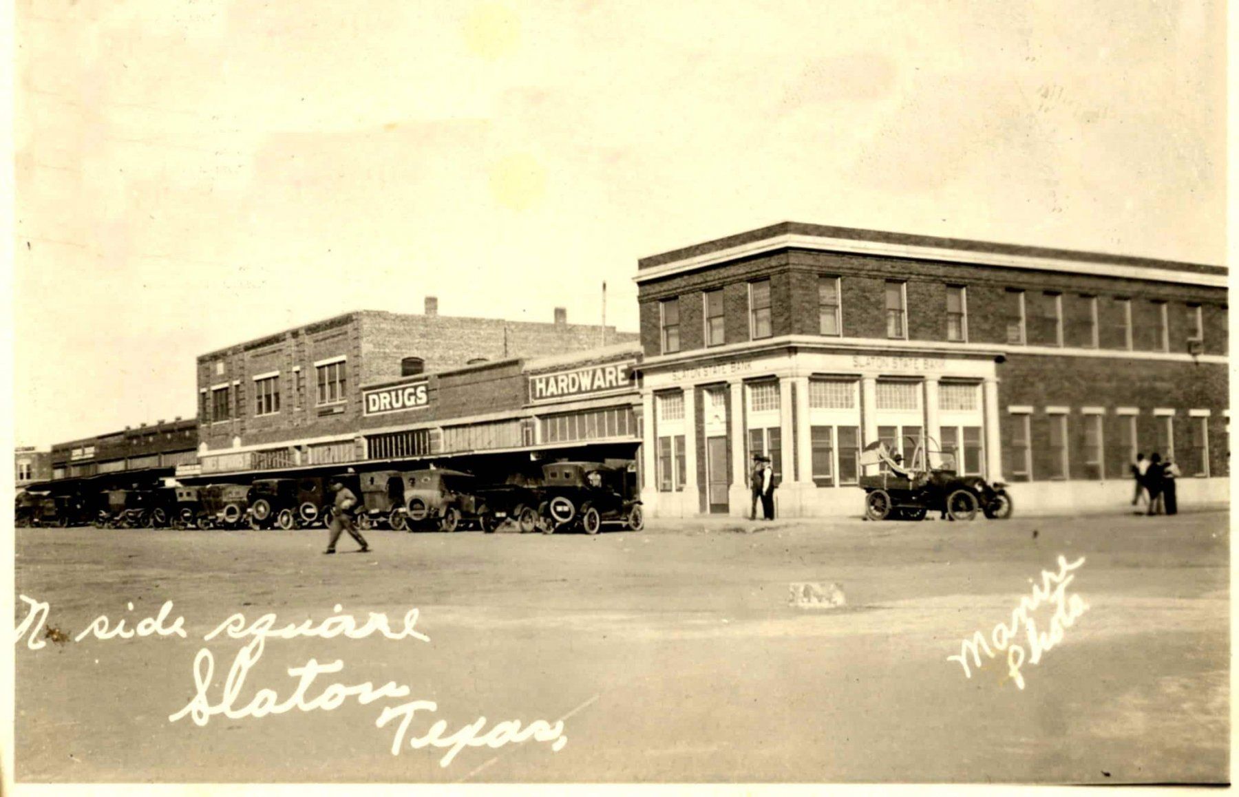 A black and white photo of a city street with a sign that says pride square