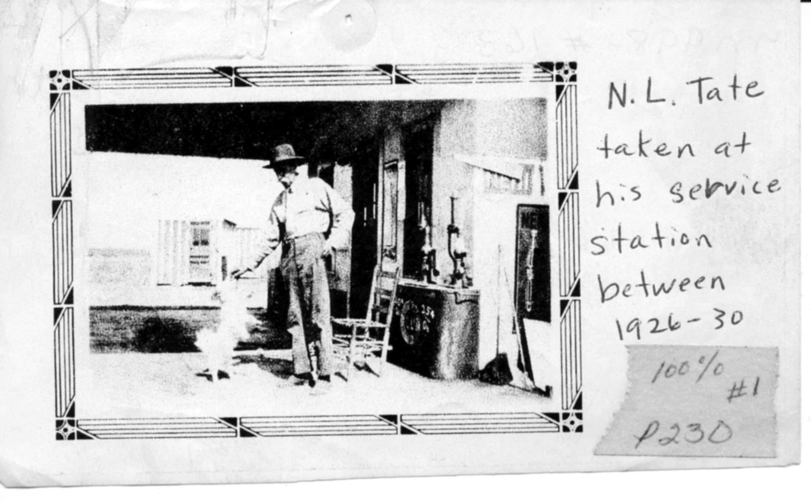 A black and white photo of n.l. tate taken at his service station between 1926-30