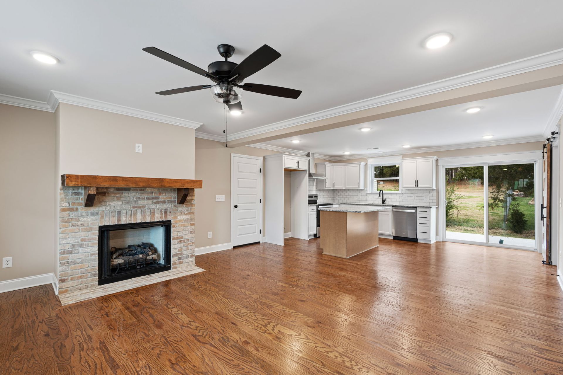 A living room with a fireplace and a ceiling fan.