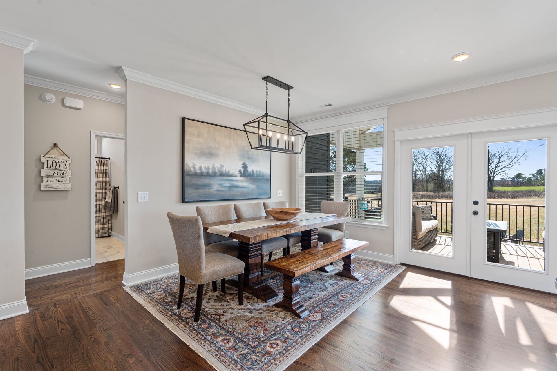 A dining room with a table and chairs and a rug.