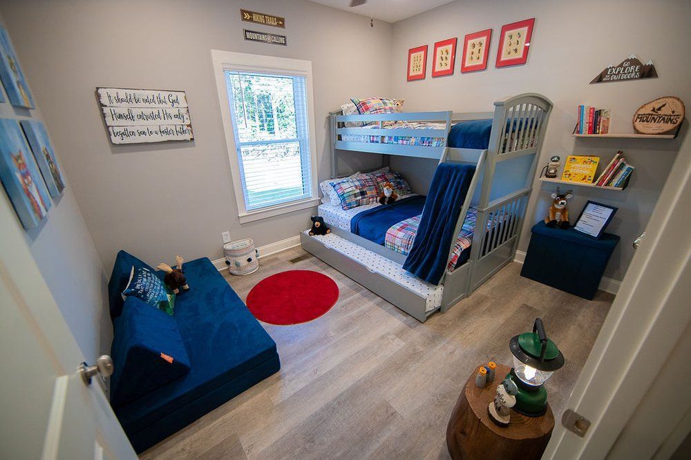 A bedroom with a bunk bed , a couch , and a window.