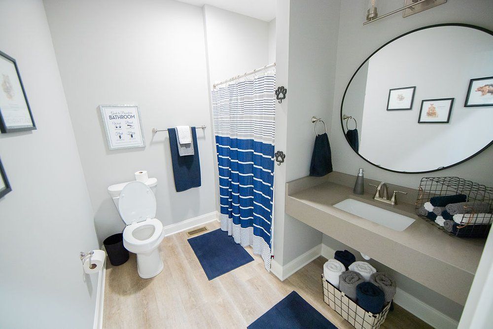 A bathroom with a toilet , sink , and shower.