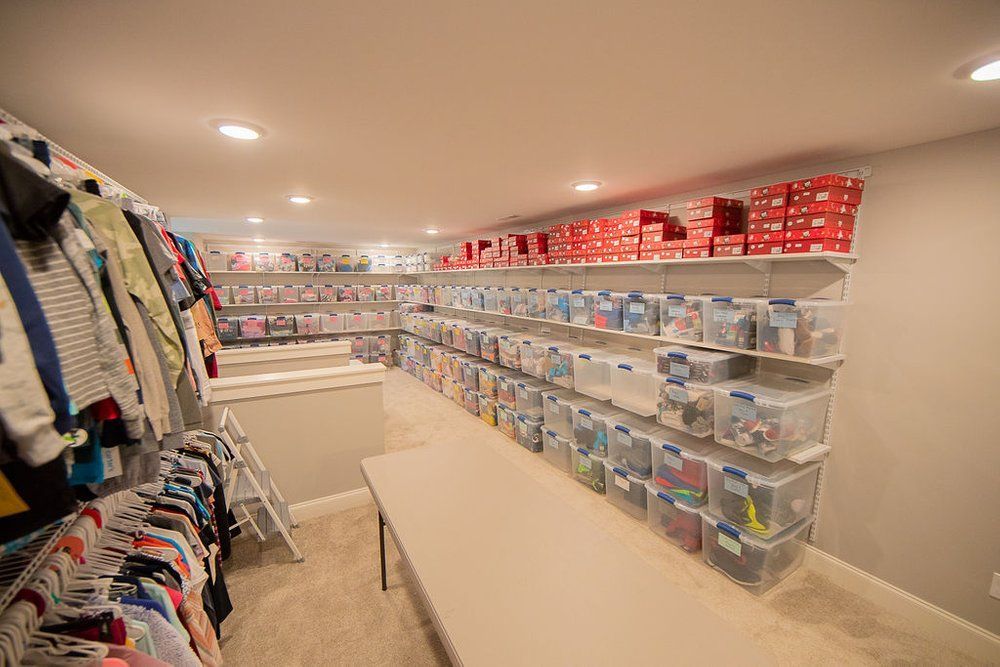 A closet filled with lots of clothes and bins.