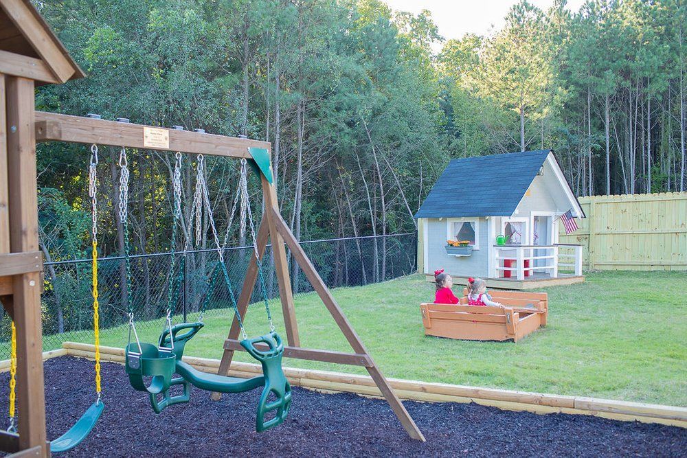 A children 's playground with a swing set and a sandbox