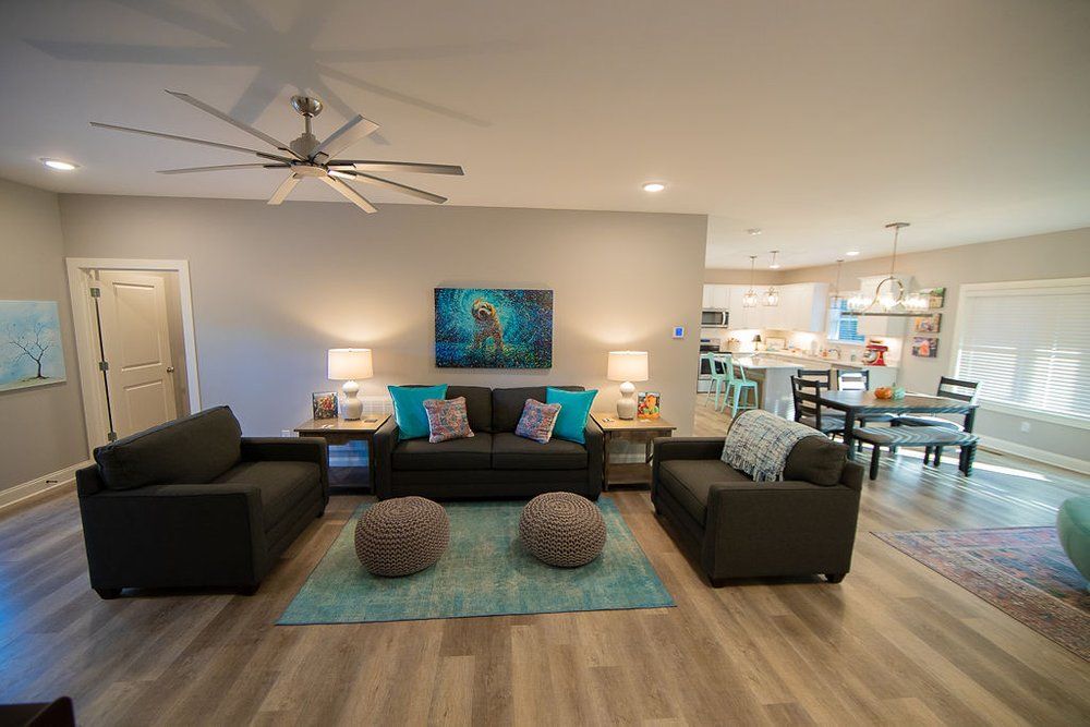 A living room filled with furniture and a ceiling fan.