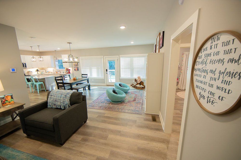 A living room with a chair and a sign on the wall.