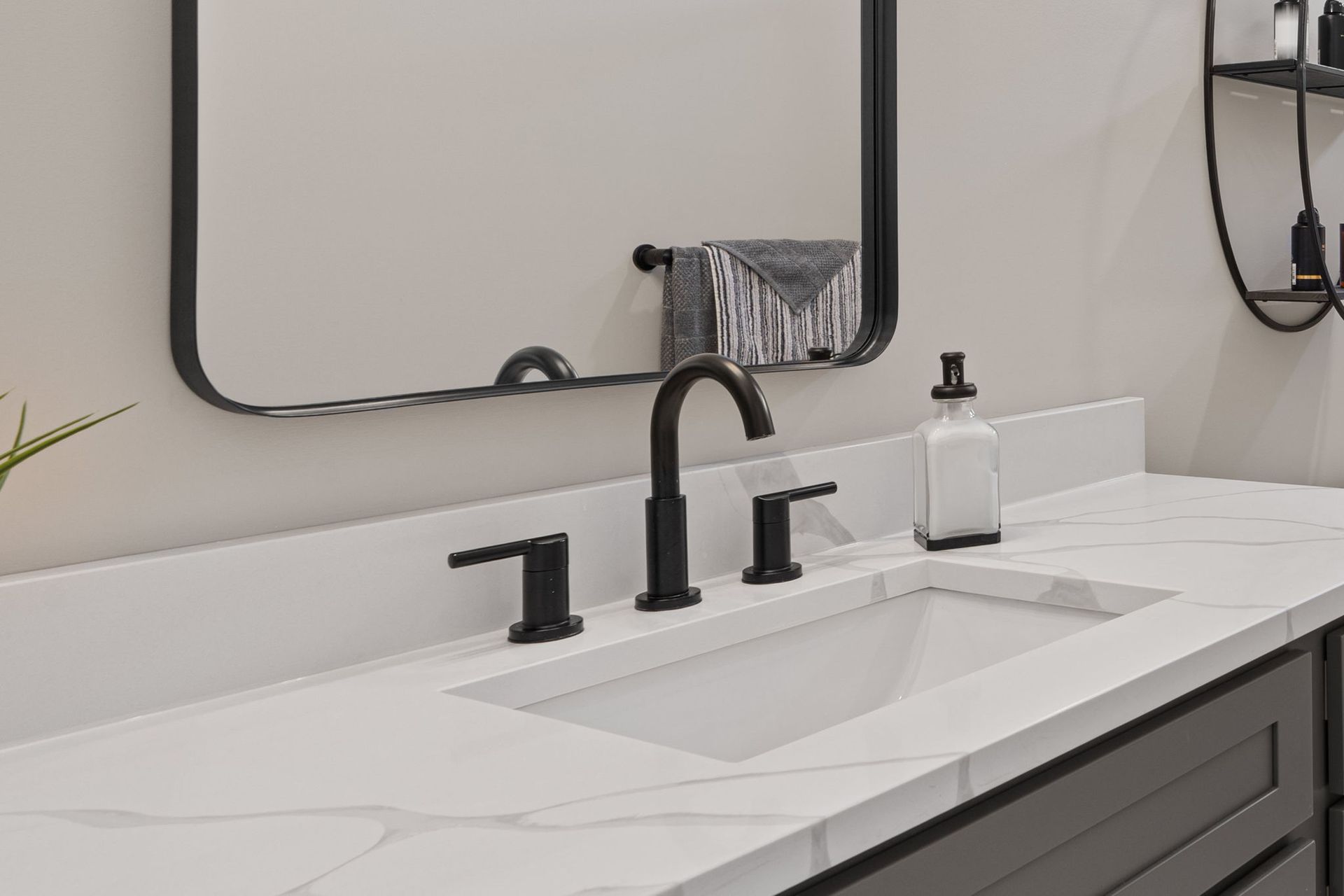 A bathroom with a sink , mirror and towel rack.