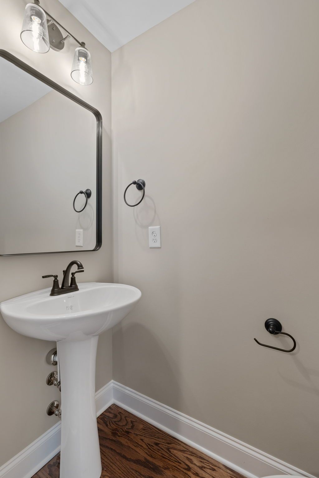 A bathroom with a pedestal sink and a mirror.