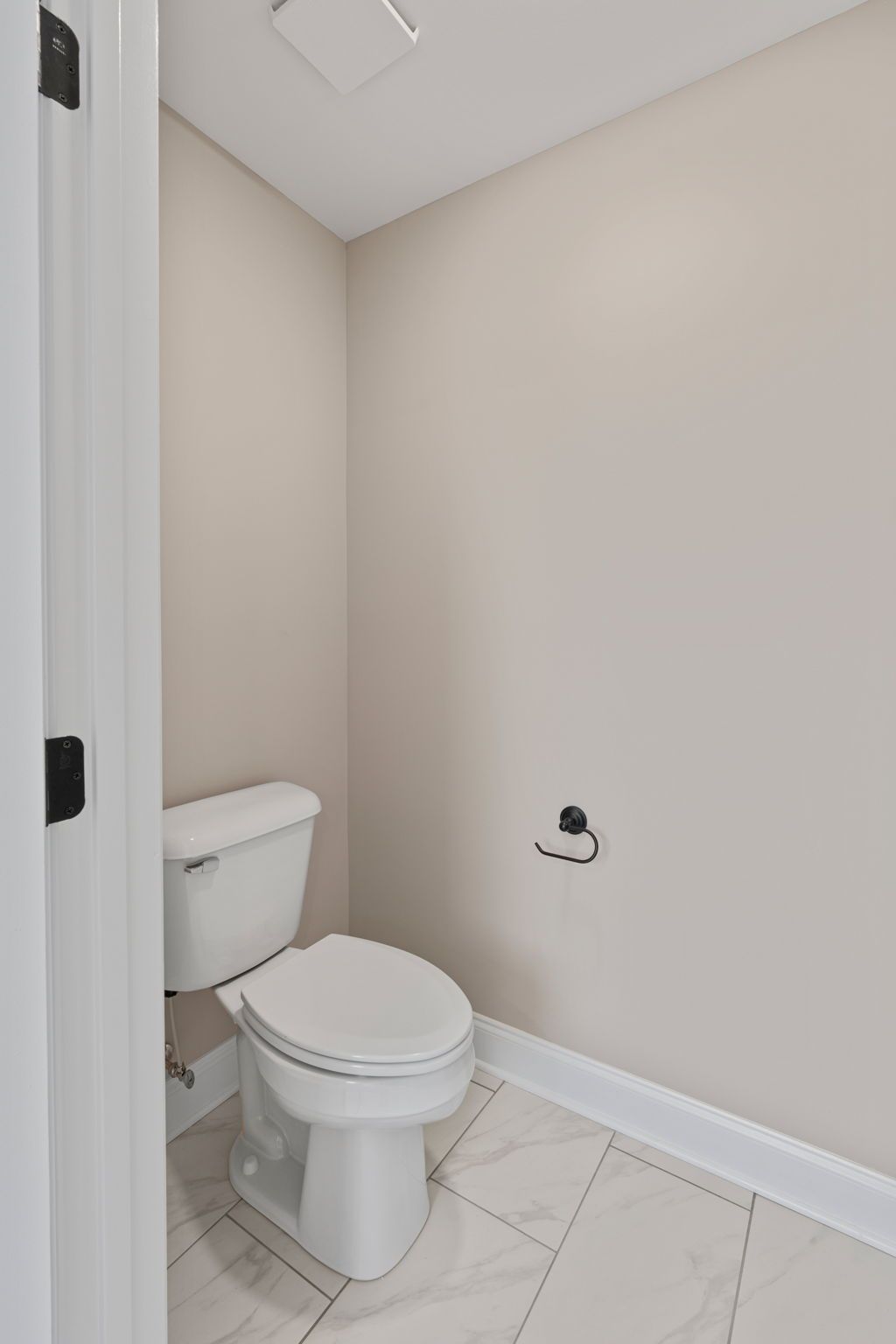 A bathroom with a toilet and a paper towel holder