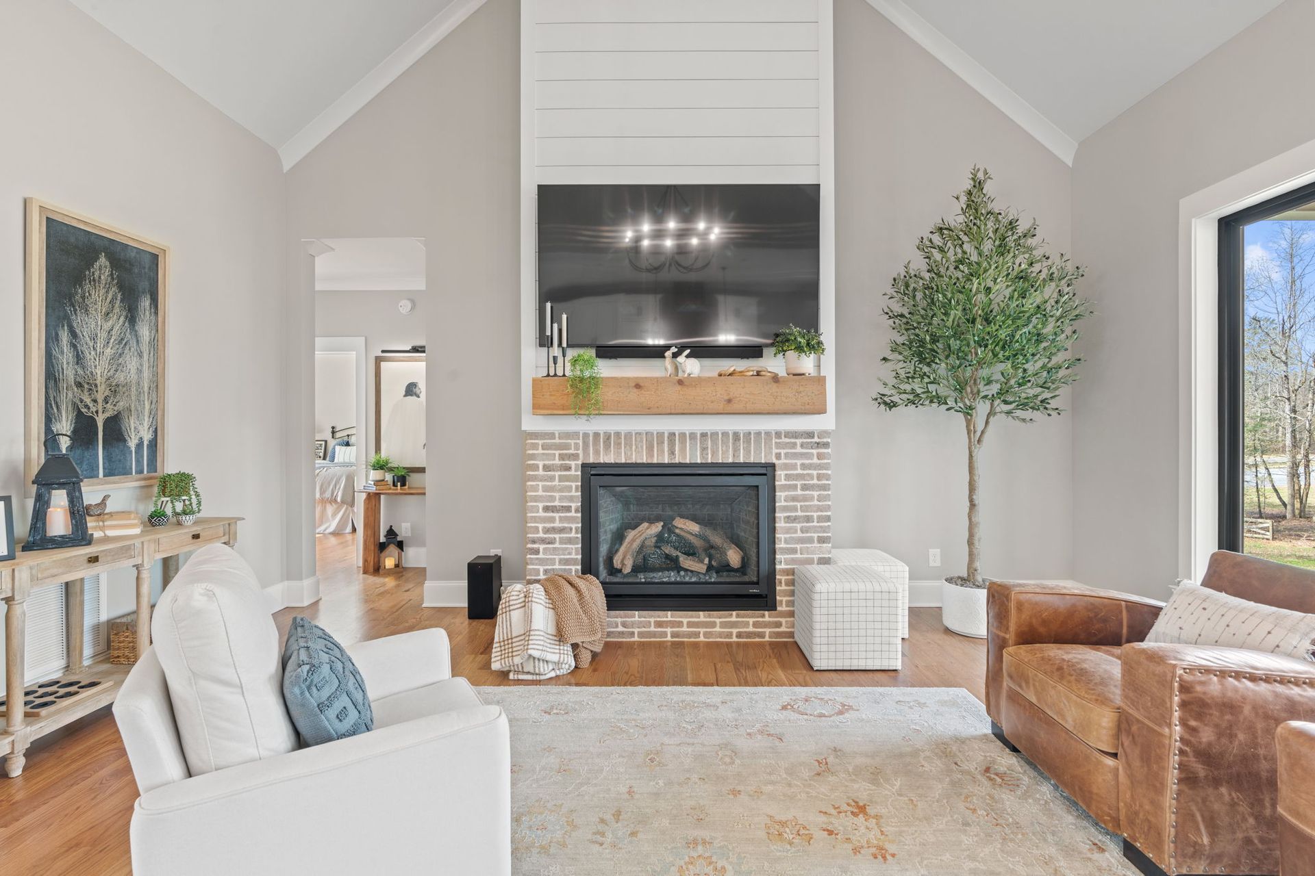 A living room with a fireplace , couch , chair and television.