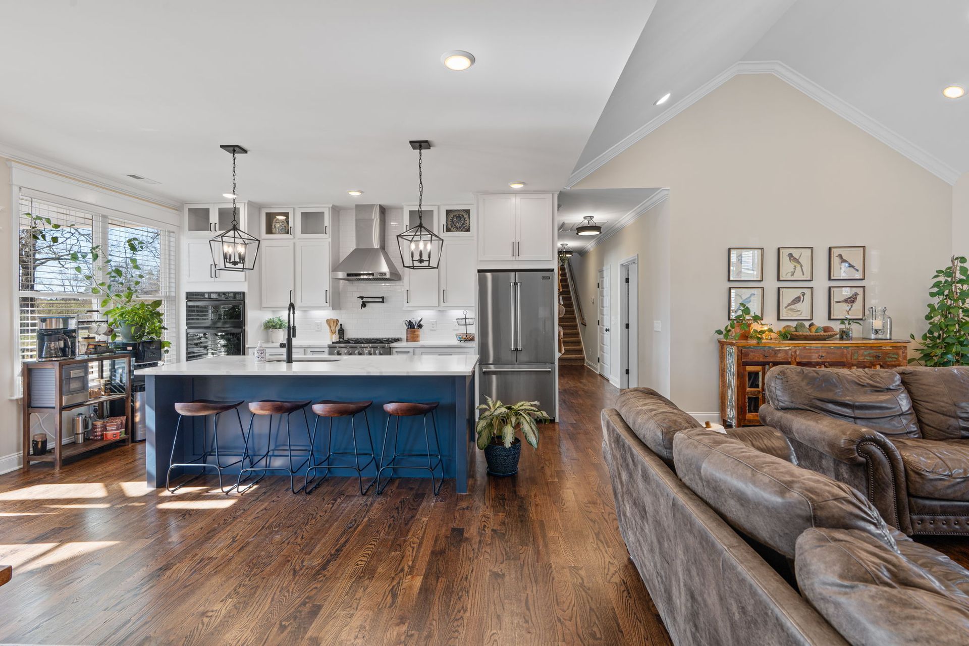 A living room and kitchen in a house with hardwood floors.