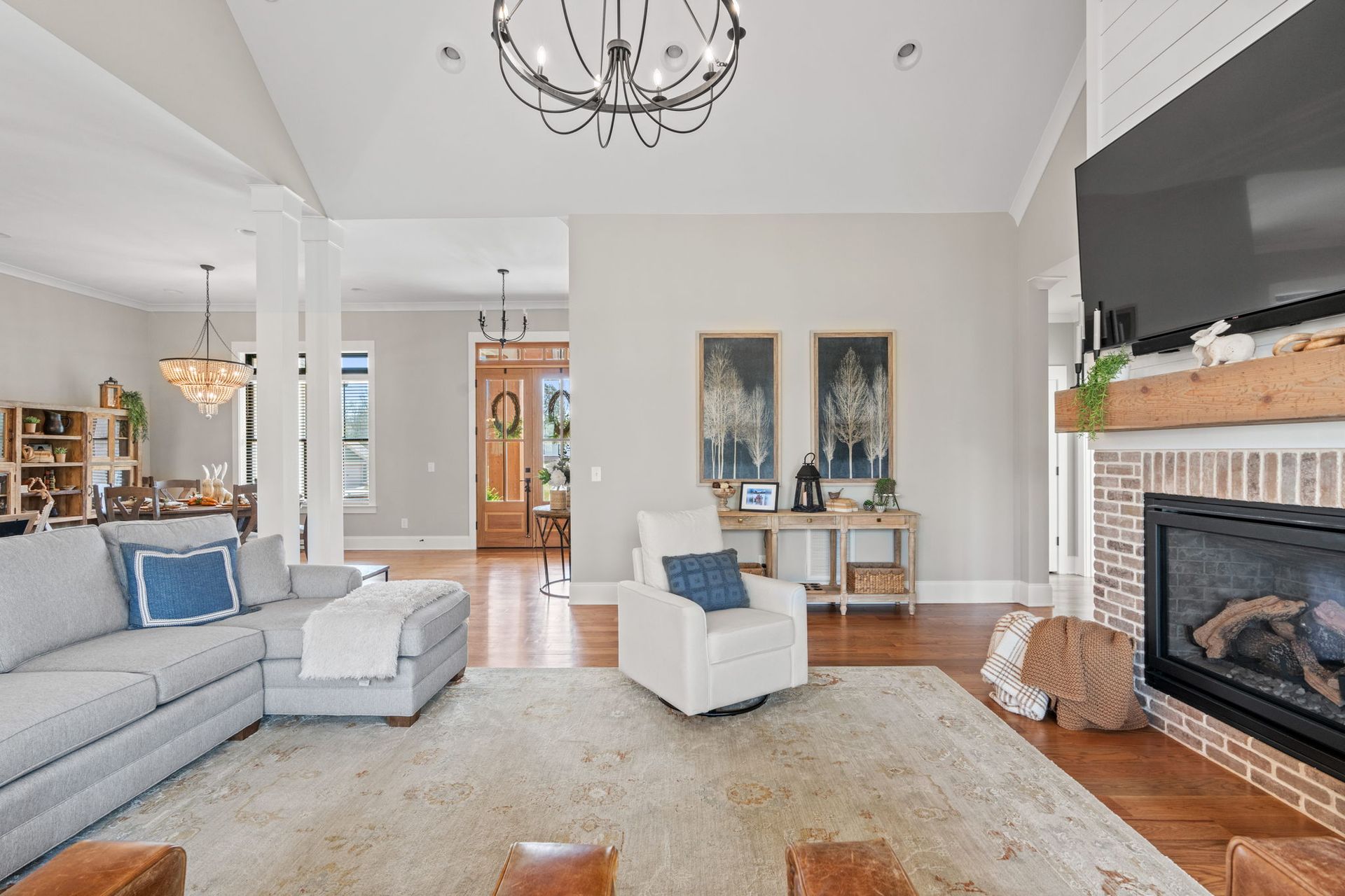 A living room with a couch , chair , fireplace and television.