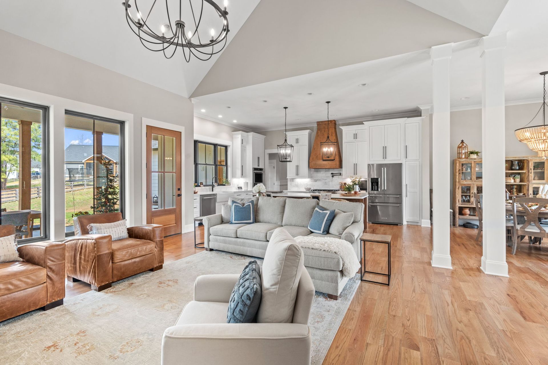 A living room with a couch , chairs , and a chandelier.