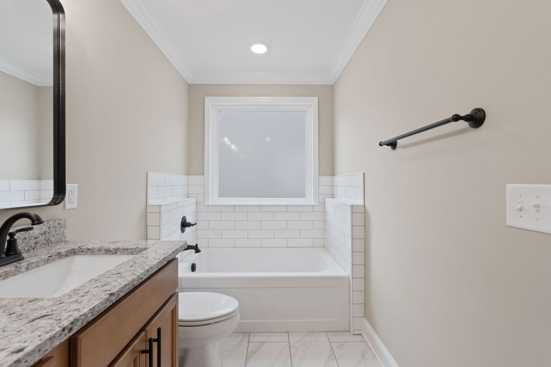 A bathroom with a sink , toilet , bathtub and mirror.