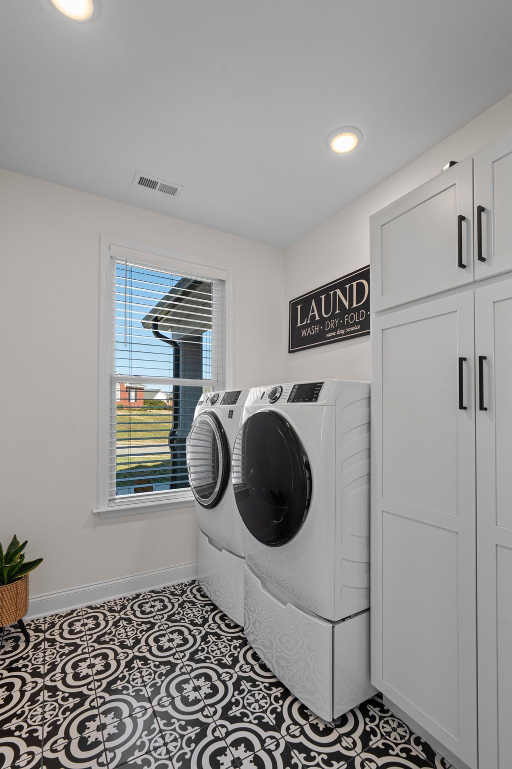 A laundry room with a washer and dryer and a window.