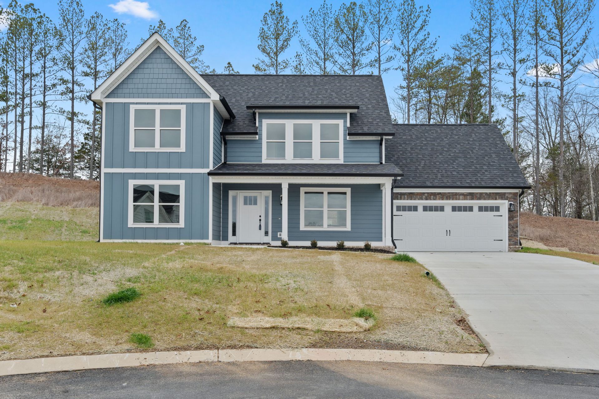 A blue house with a gray roof and white trim